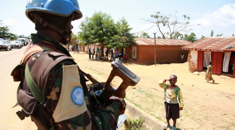 A Congolese child saluting a UN peacekeeper. Photo MONUSCO/Abel Kavanagh, Wikipedia Commons.