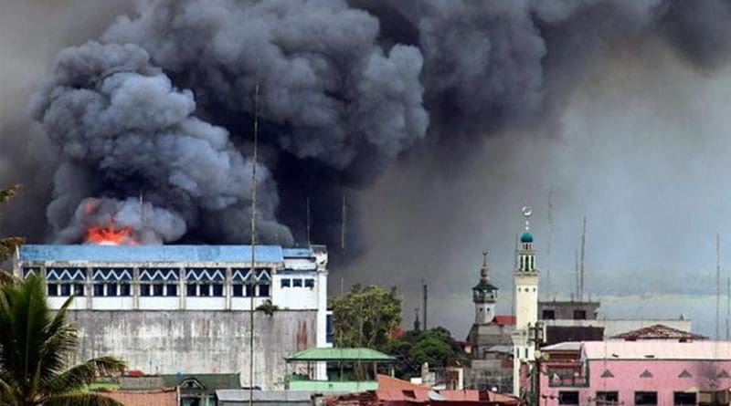 A building in Marawi is set ablaze by airstrikes carried out by the Philippine Air Force. Photo by Mark Jhomel, Wikipedia Commons.
