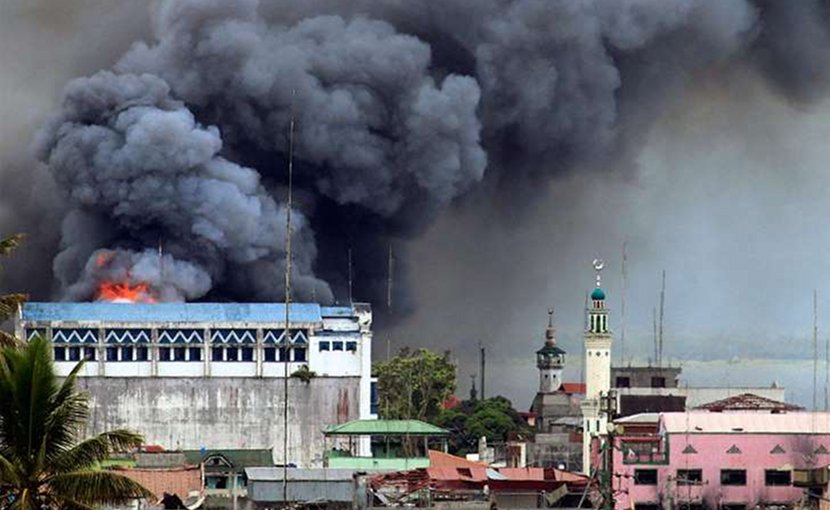 A building in Marawi is set ablaze by airstrikes carried out by the Philippine Air Force. Photo by Mark Jhomel, Wikipedia Commons.