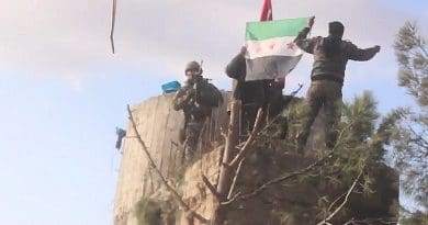 TFSA fighters on the top of Barsaya mountain, hoisting the Turkish and Syrian indepedence flag while shouting "Allāhu akbar". Photo Credit: Qasioun News Agency, Wikipedia Commons.