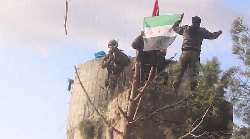 TFSA fighters on the top of Barsaya mountain, hoisting the Turkish and Syrian indepedence flag while shouting "Allāhu akbar". Photo Credit: Qasioun News Agency, Wikipedia Commons.