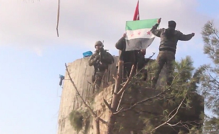 TFSA fighters on the top of Barsaya mountain, hoisting the Turkish and Syrian indepedence flag while shouting "Allāhu akbar". Photo Credit: Qasioun News Agency, Wikipedia Commons.