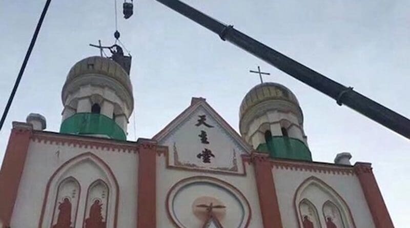 Under orders from communist authorities, workers in a crane get to work on removing religious features from Yining Catholic Church in Urumqi Diocese. (Photo supplied)