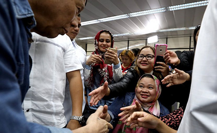 President Rodrigo Duterte greets Filipino migrant workers returning from the Middle East in February. (Photo courtesy of the Presidential Communications Office)