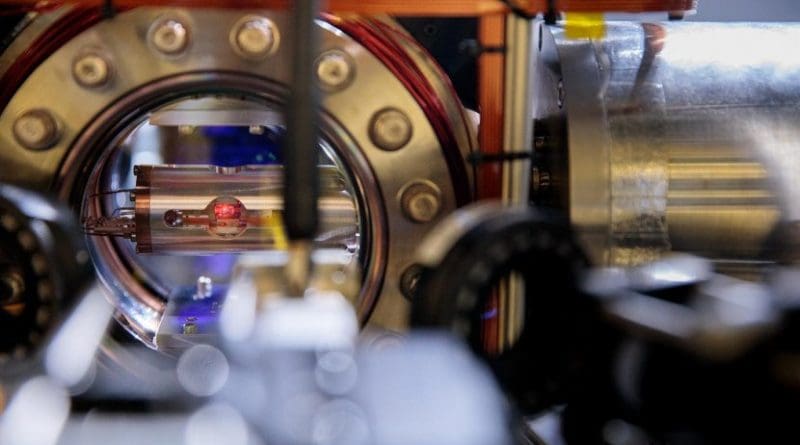 Look into the heart of an atomic clock. Here, a single atom is trapped in the metal vacuum chamber with the round window. The clock's tick comes from a laser tuned to interact with this atom. Credit Centre for Quantum Technologies, National University of Singapore