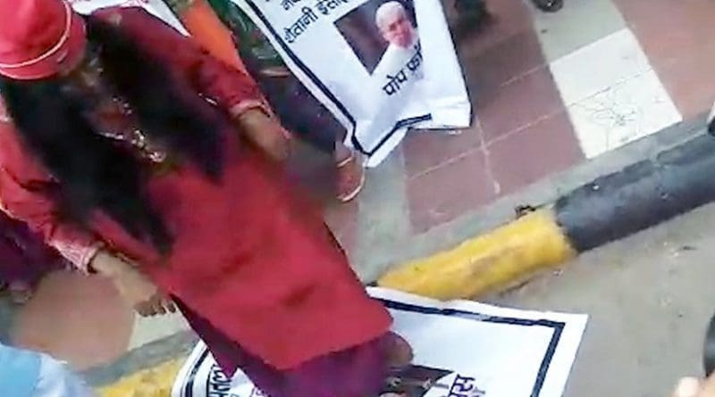 A still image of a man believed to be controversial Hindu leader Om Swami Maharaj stomping on a picture of Pope Francis. (YouTube screengrab)