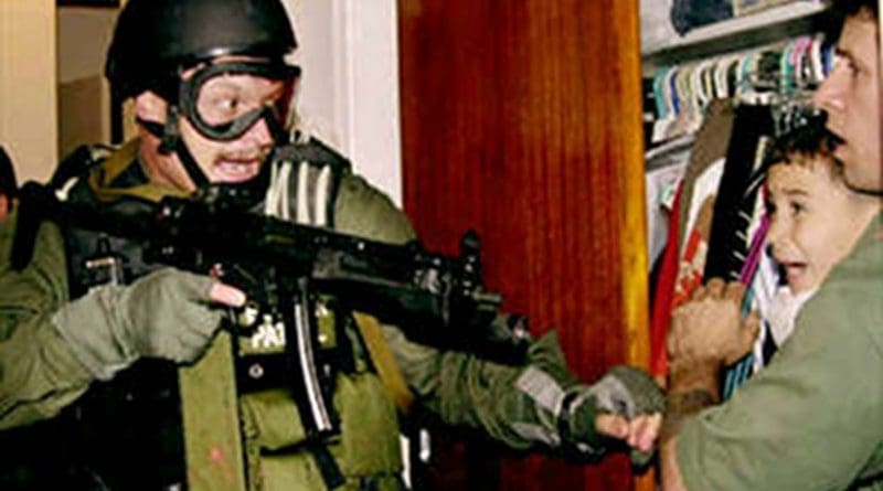 Unidentified border patrol officer during the seizure of Elián González from his uncle's residence on April 22, 2000. Photo Credit: Lowe resolution of photograph taken by Alan Diaz of the Associated Press, Wikimedia Commons.