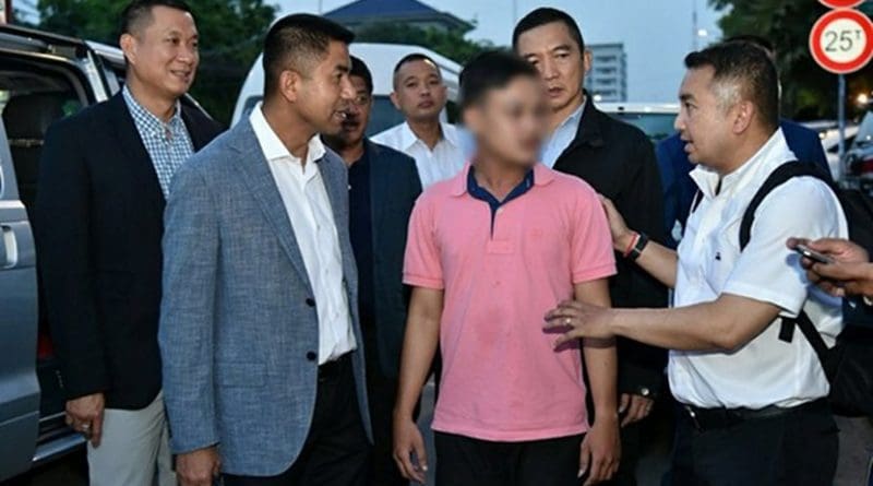 Thai police Maj. Gen. Surachate Hakpal (second from left) takes Ratanak Heng (wearing pink shirt) under his custody in Phnom Penh, May 31, 2018. Thai authorities blurred the suspect’s face in this handout photo. Courtesy of Thailand’s Tourist Police Bureau