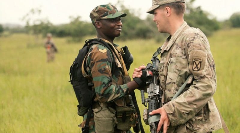 A Ghanaian soldier greets a U.S. soldier from the 1st Battalion, 32nd Infantry Regiment, during a field training exercise for the United Accord exercise at the Bundase Training Camp in Ghana, July 16, 2018. United Accord 2018 is hosted by the Ghanaian armed forces and U.S. Army Africa and consists of four combined, joint components: a command post exercise, field training exercise, jungle warfare school and medical readiness training exercise. Navy Photo by Petty Officer 2nd Class Douglas Parker