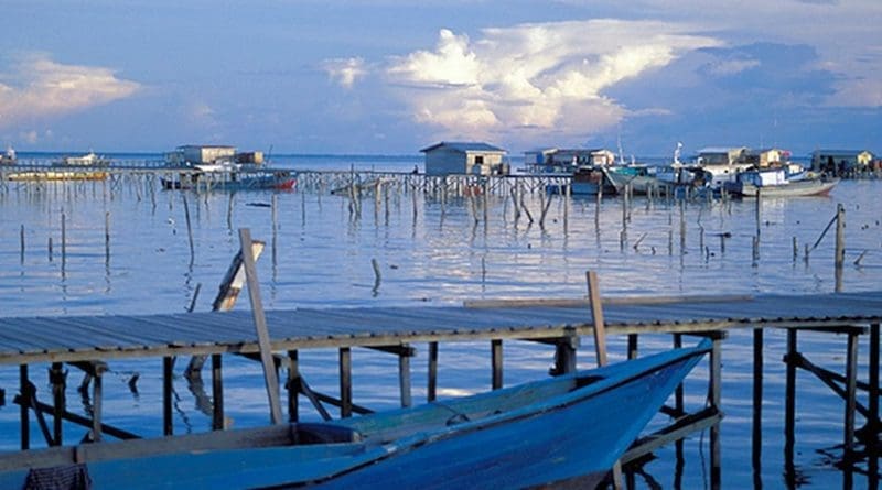 Home and boats on the water. © Curt Carnemark/World Bank