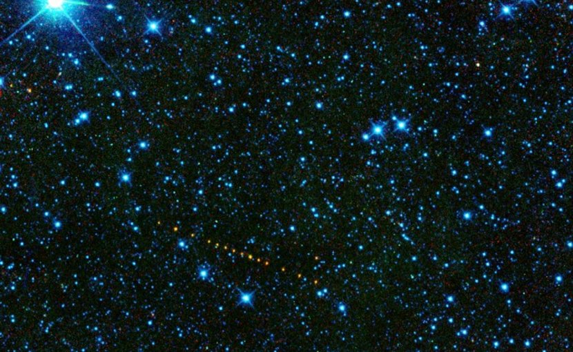 This is a collection of images from the WISE spacecraft of the asteroid 2305 King, which is named after Martin Luther King Jr. The asteroid appears as a string of orange dots because this is a set of exposures that have been added together to show its motion across the sky. These infrared pictures have been color-coded so that we can perceive them with the human eye: 3.4 microns is represented as blue; 4.6 microns is green, 12 microns is yellow, and 22 microns is shown as red. From the WISE data, we can compute that the asteroid is about 12.7 kilometers in diameter, with a 22% reflectivity, indicating a likely stony composition. Credit NASA