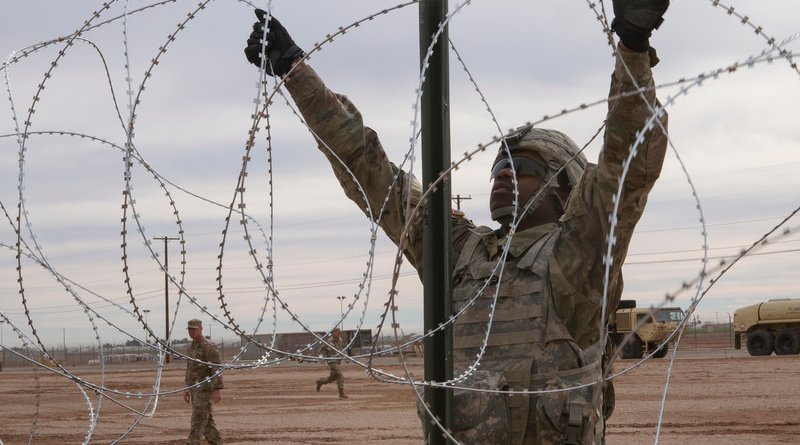 Soldier with 541st Engineer Company, Special Purpose Marine Air-Ground Task Force 7, moves concertina wire over stake on practice barricade at Naval Air Facility El Centro in California. (U.S. Marine Corps/Asia J. Sorenson)