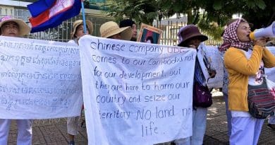 Villagers protesting UDG outside the Chinese Embassy hold up signs and chant into a megaphone. Photo by Andrew Nachemson.