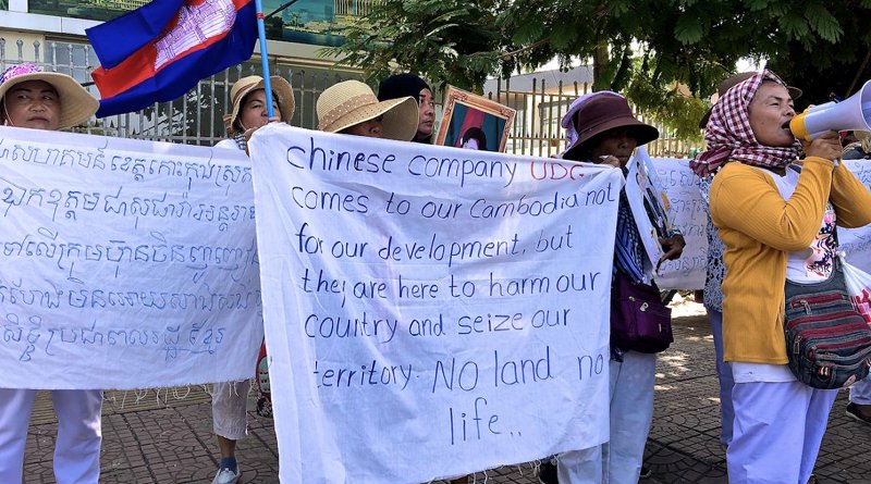 Villagers protesting UDG outside the Chinese Embassy hold up signs and chant into a megaphone. Photo by Andrew Nachemson.
