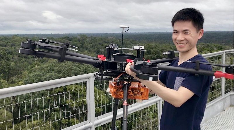 Jianhuai Ye, a postdoctoral fellow at SEAS, holds a sampling drone on a tower in the Amazon. Credit (Image courtesy of Jianhuai Ye/ Harvard SEAS