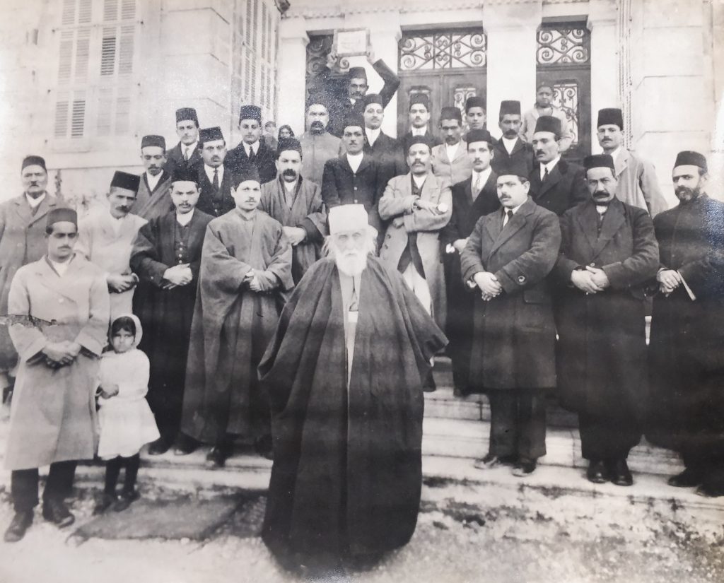 Guardian of the Faith, Abdul Baha (centre), surrounded by Indian and local Baha’is on the steps of his home in Bahji, near Haifa.