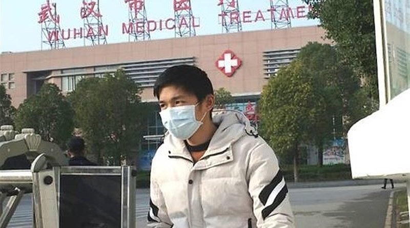 Man wearing mask in front of a hospital in Wuhan, China. Photo Credit: Tasnim News Agency