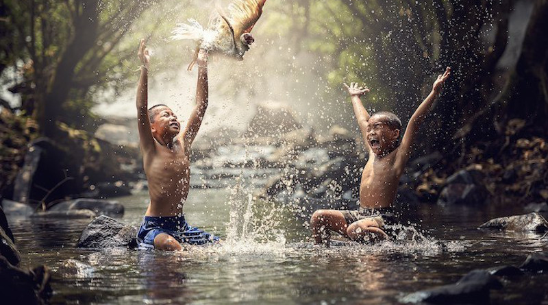 Happy children splashing water. Source: Wikimedia Commons.