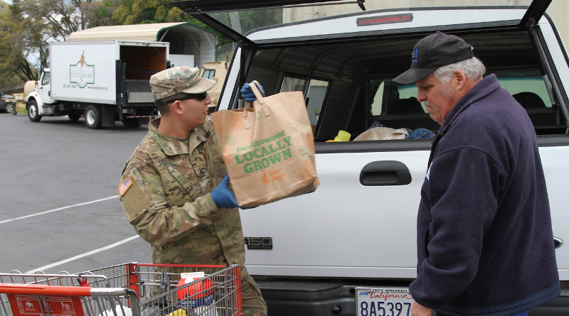 Sgt. Moises Castillo of the California Army National Guard helps an Amador County resident load food supplies into a vehicle at the Interfaith Food Bank in Jackson, Calif., March 23, 2020. Photo Credit: Army National Guard Staff Sgt. Eddie Siguenza