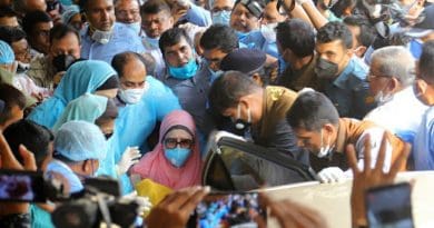 Bangladeshi opposition leader Khaleda Zia (wearing a mask and pink head covering) is wheeled to her car as she leaves the Bangabandhu Sheikh Mujib Medical University Hospital in Dhaka following her release from custody, March 25, 2020. Photo Credit: BenarNews