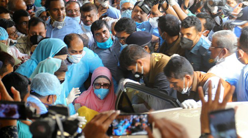 Bangladeshi opposition leader Khaleda Zia (wearing a mask and pink head covering) is wheeled to her car as she leaves the Bangabandhu Sheikh Mujib Medical University Hospital in Dhaka following her release from custody, March 25, 2020. Photo Credit: BenarNews