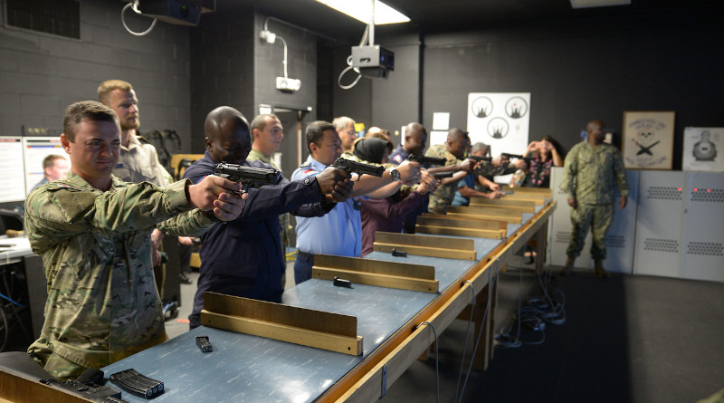 Foreign students try out a firearms training simulator at the Center for Surface Combat Systems Unit, Naval Station Great Lakes, Ill., Sept. 10, 2019. Photo Credit: Brian Walsh, Navy