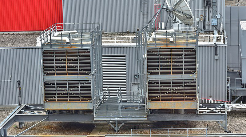 A typical evaporative, open-loop cooling tower rejecting heat from the condenser water loop of an industrial chiller unit. Photo Credit: Saud, Wikipedia Commons