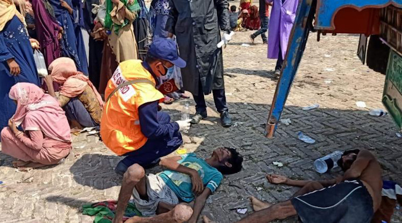 A screenshot of an exhausted Rohingya refugee receiving aid from the Bangladeshi coast guard. ©2020 Bangladeshi Coast Guard/Facebook