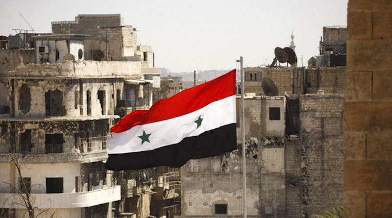Syria's flag flies in bombed city. Photo Credit: Mil.ru