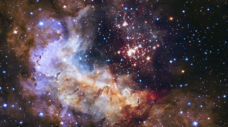 The brilliant tapestry of young stars flaring to life resembles a glittering fireworks display in this Hubble Space Telescope image. The sparkling centerpiece of this fireworks show is a giant cluster of thousands of stars called Westerlund 2. The cluster resides in a raucous stellar breeding ground known as Gum 29, located 20,000 light-years away from Earth in the constellation Carina. Hubble's Wide Field Camera 3 pierced through the dusty veil shrouding the stellar nursery in near-infrared light, giving astronomers a clear view of the nebula and the dense concentration of stars in the central cluster. The cluster measures between six light-years and 13 light-years across. CREDIT Credits: NASA, ESA, the Hubble Heritage Team (STScI/AURA), A. Nota (ESA/STScI) and the Westerlund 2 Science Team