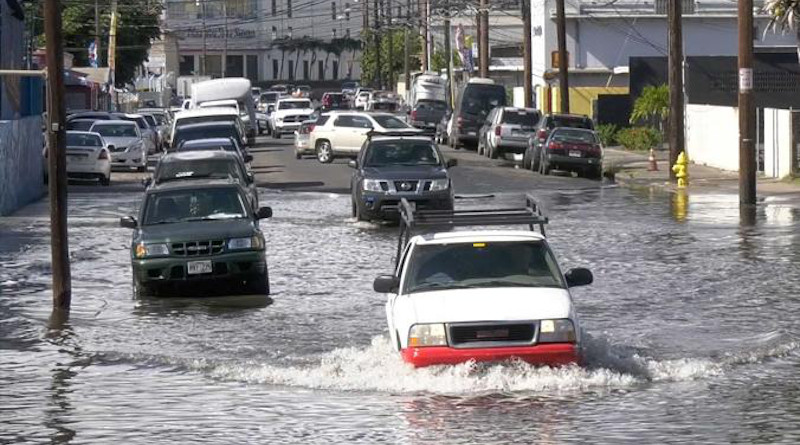 Vehicles drive through a flooded road in Honolulu. CREDIT Hawaii Sea Grant King Tides Project