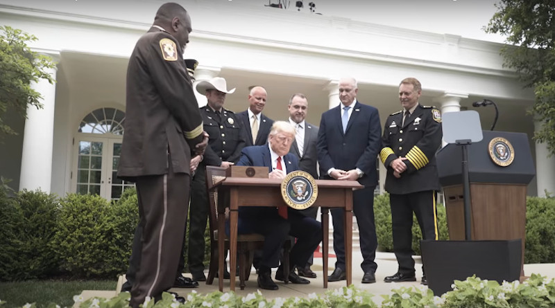 US President Donald Trump signs an executive order outlining some police reforms. Photo Credit: White House video screenshot