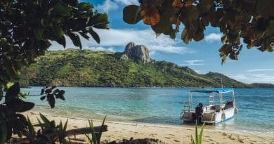A boat rests on the shores of Fiji. Unsplash / Nicolas Weldingh