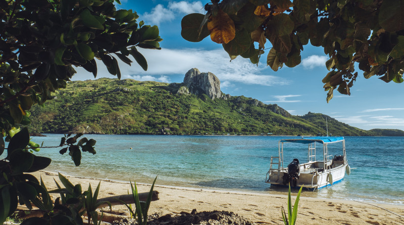 A boat rests on the shores of Fiji. Unsplash / Nicolas Weldingh