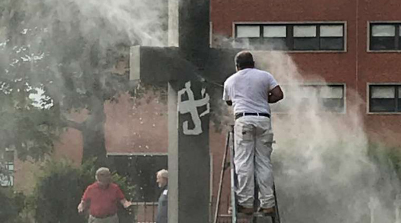 Paint is removed from the central cross at the campus cemetery, Providence College, June 22. Image courtesy of NBC10/ WJAR