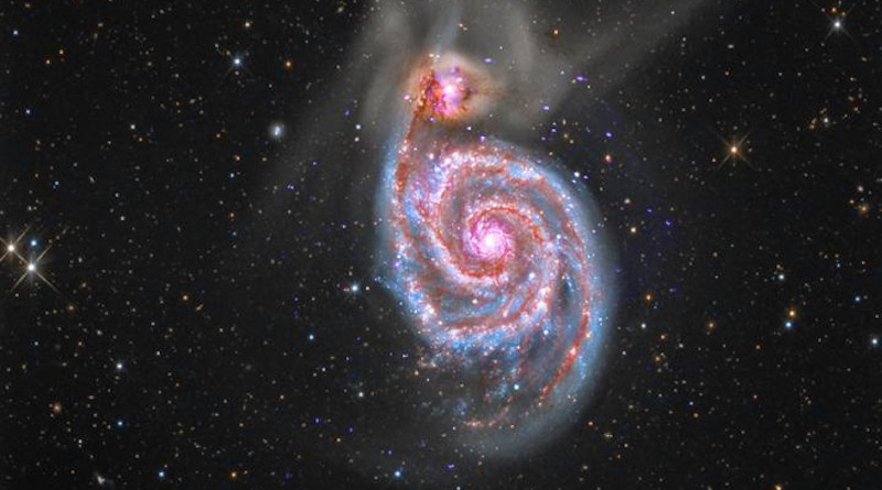 Galaxy M51 is a spiral galaxy, about 30 million light years away, that is in the process of merging with a smaller galaxy seen to its upper left. CREDIT Image credit: X-ray: NASA/CXC/SAO; Optical: Detlef Hartmann; Infrared: Courtesy NASA/JPL-Caltech.