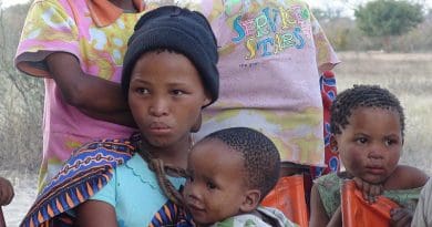 The daughters of a small community of San bushmen living in Namibia. The baby boy is the girl's brother. Photo Credit: Nicolas M. Perrault, Wikipedia Commons