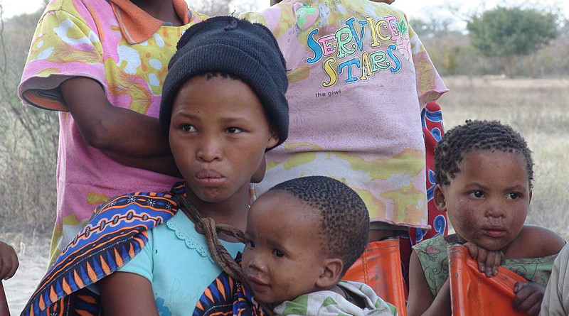 The daughters of a small community of San bushmen living in Namibia. The baby boy is the girl's brother. Photo Credit: Nicolas M. Perrault, Wikipedia Commons