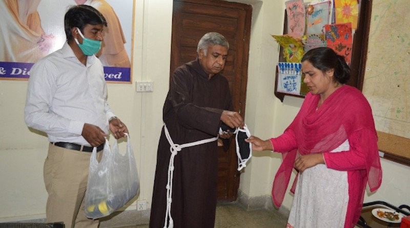 Father Francis Nadeem distributes face masks in Lahore in April. He died on July 3 at 65. (Photo: NCIDE)