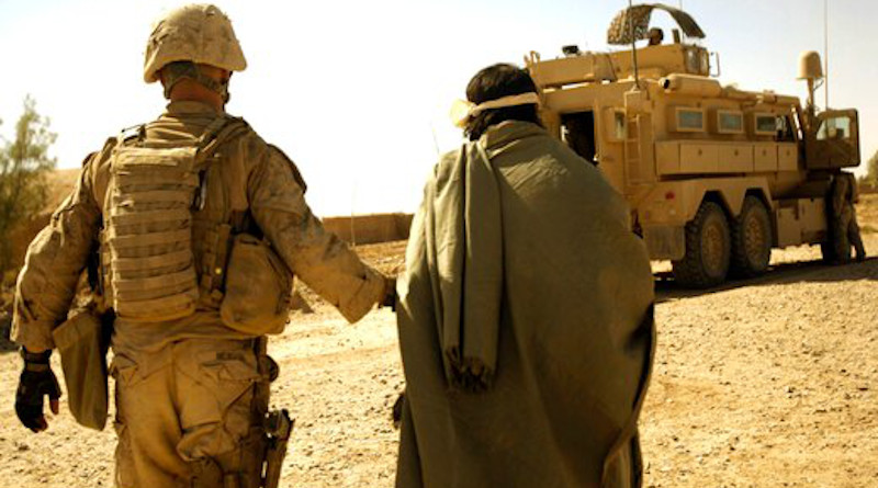 Marine with Combined Anti-Armor Team 1, 1st Battalion, 5th Marine Regiment, escort enemy prisoner of war away for questioning after discovering illegal drugs and improvised explosive device–making material, Helmand Province, Afghanistan, October 19, 2009 (U.S. Marine Corps/John McCall)