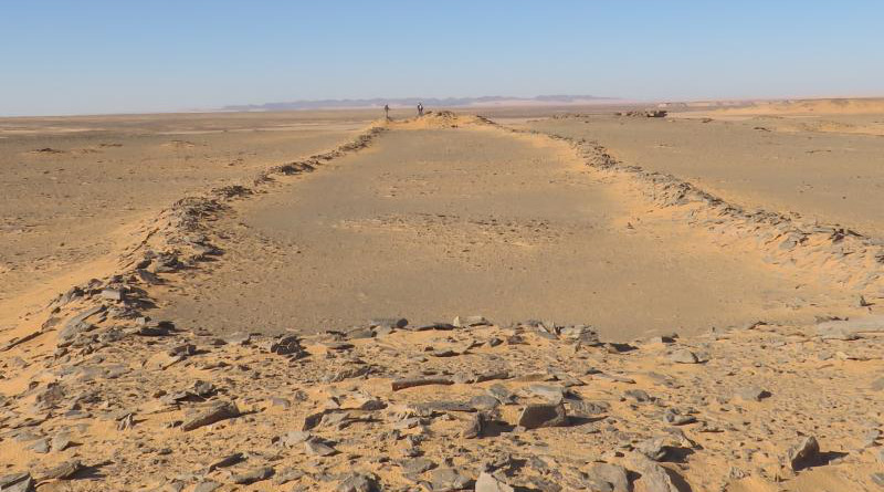 New archaeological research in Saudi Arabia documents hundreds of stone structures interpreted as monumental sites where early pastoralists carried out rituals. Image shows character of these structures as two platforms connected by low walls, note researchers at far end for scale. CREDIT: Huw Groucutt