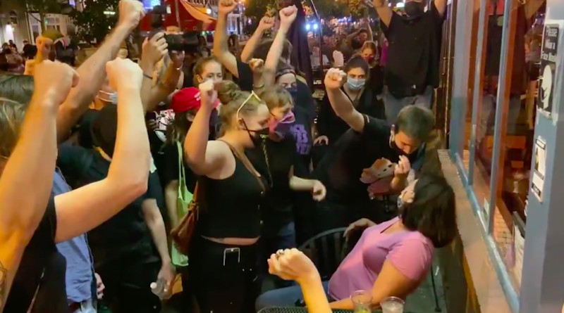 Black Lives Matter (BLM) activists intimidating people seated outdoors at a restaurant. Photo Credit: Screenshot via Twitter