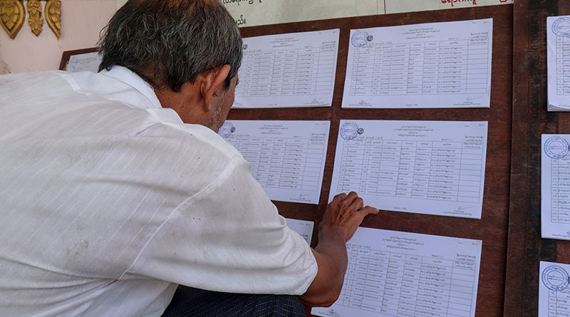 Man reads electoral lists in Myanmar. Photo Credit: DMG