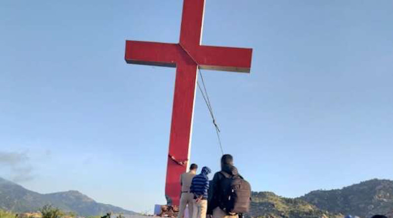 Police remove a cross from a hill near a Catholic parish in Karnataka state on Sept. 23 after accusing Christians of erecting it without permission on government land. (Photo supplied)