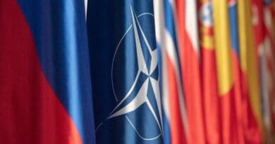 The NATO flag hangs in the plenary room at the NATO Military Committee Conference in Ljubljana, Slovenia. Photo Credit: Navy Petty Officer 1st Class Dominique A. Pineiro, DOD