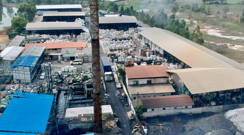 Drone view of Thai "dioxin factory" where circuit boards and wires are burned in a giant smelter. Toxic smoke belches from the stack, while ash piles are visible in foreground, and imported electronic equipment seen in the background. Copyright BAN, February 2, 2018.