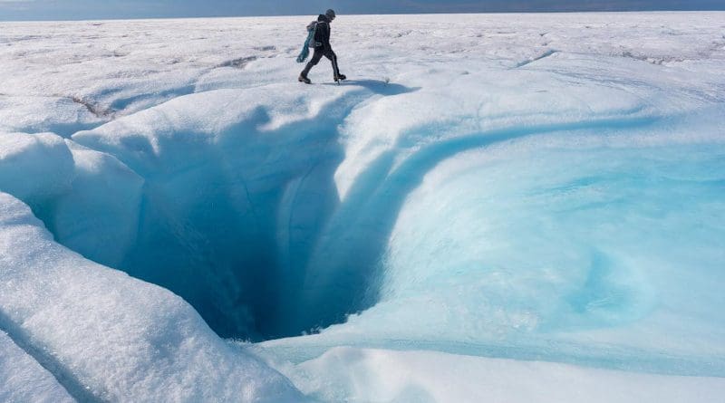 University of Arkansas associate professor of geosciences Matt Covington investigates a moulin on the Greenland ice sheet. CREDIT: Jason Gulley