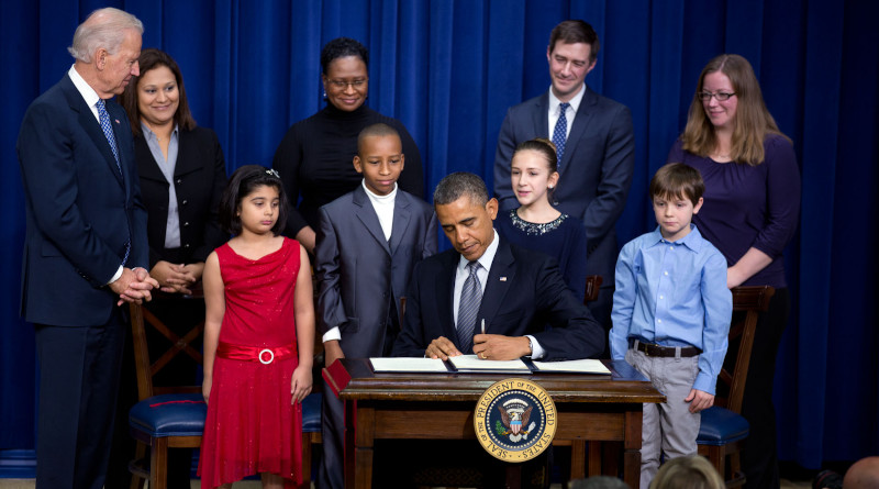 President Barack Obama, with Vice President Joe Biden, signs executive orders initiating 23 separate executive actions, after delivering remarks to unveil new gun control proposals as part of the Administration’s response to the Newtown, Conn., shootings, and other tragedies, in the Eisenhower Executive Office Building, Jan. 16, 2013. Joining them on stage are children from around the country who wrote the President letters in the wake of the Newtown tragedy expressing their concerns about gun violence and school safety, and their parents. (Official White House Photo by Lawrence Jackson)