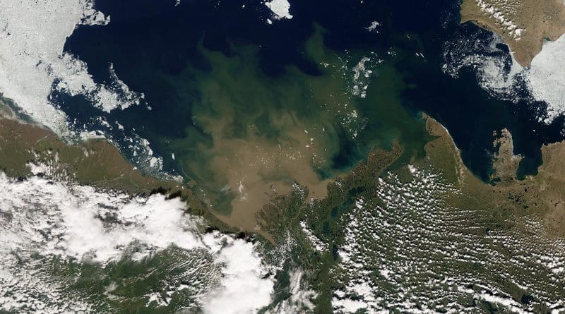 Water from Canada's Mackenzie River enters the blue Arctic Ocean in July 2012. White areas in the top half of the photo are largely sea ice, while those below are clouds over land. CREDIT: Photo by NASA Earth Observatory