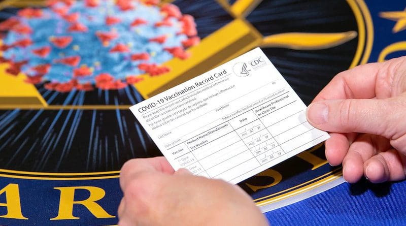 A Department of Health and Human Services employee holds a COVID-19 vaccine record card. Photo Credit: EJ Hersom, DOD